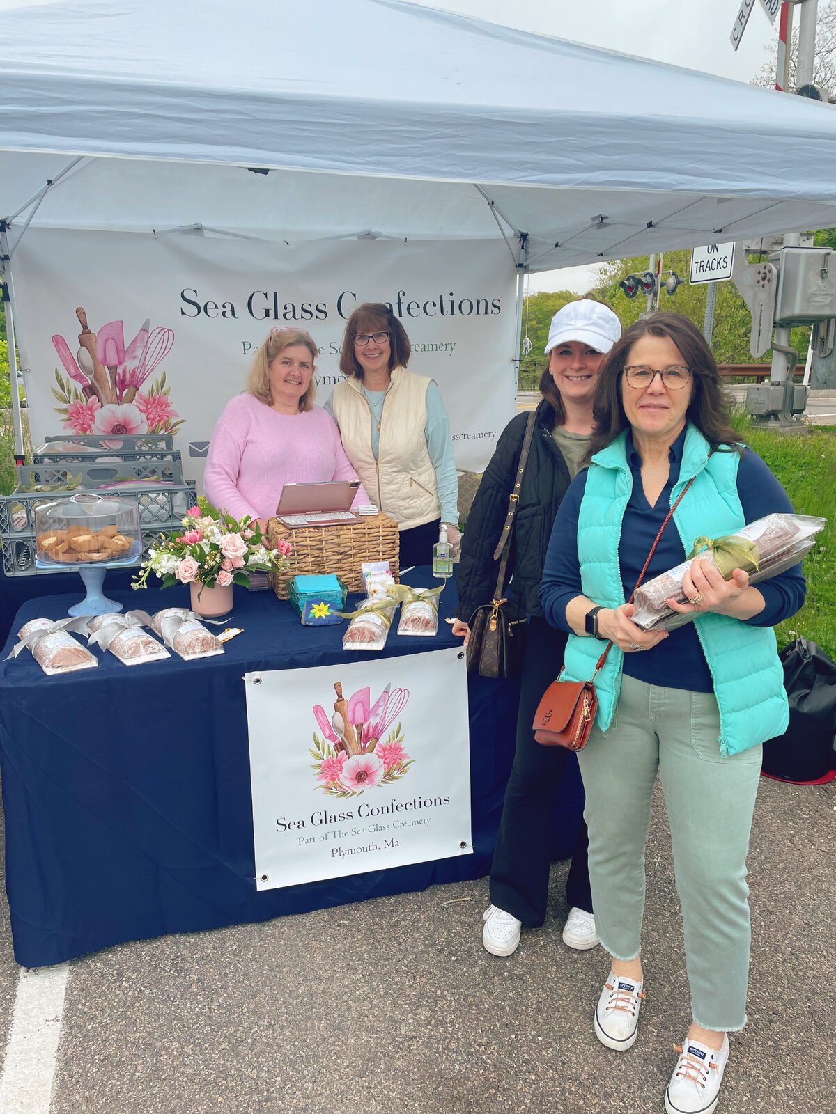 Sea Glass Confections farmers market booth with Donna and Leslie