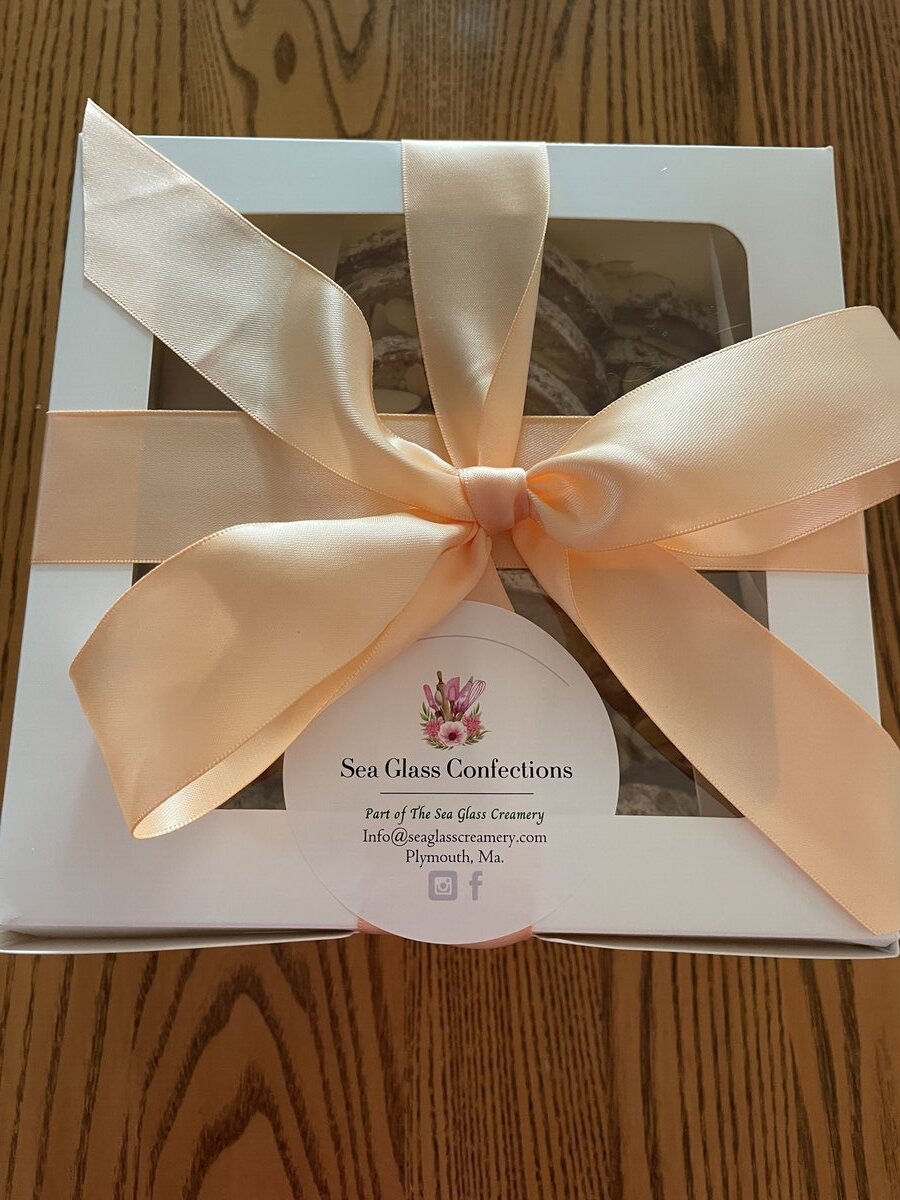 Holiday gift boxes with almond cakes and festive ribbons