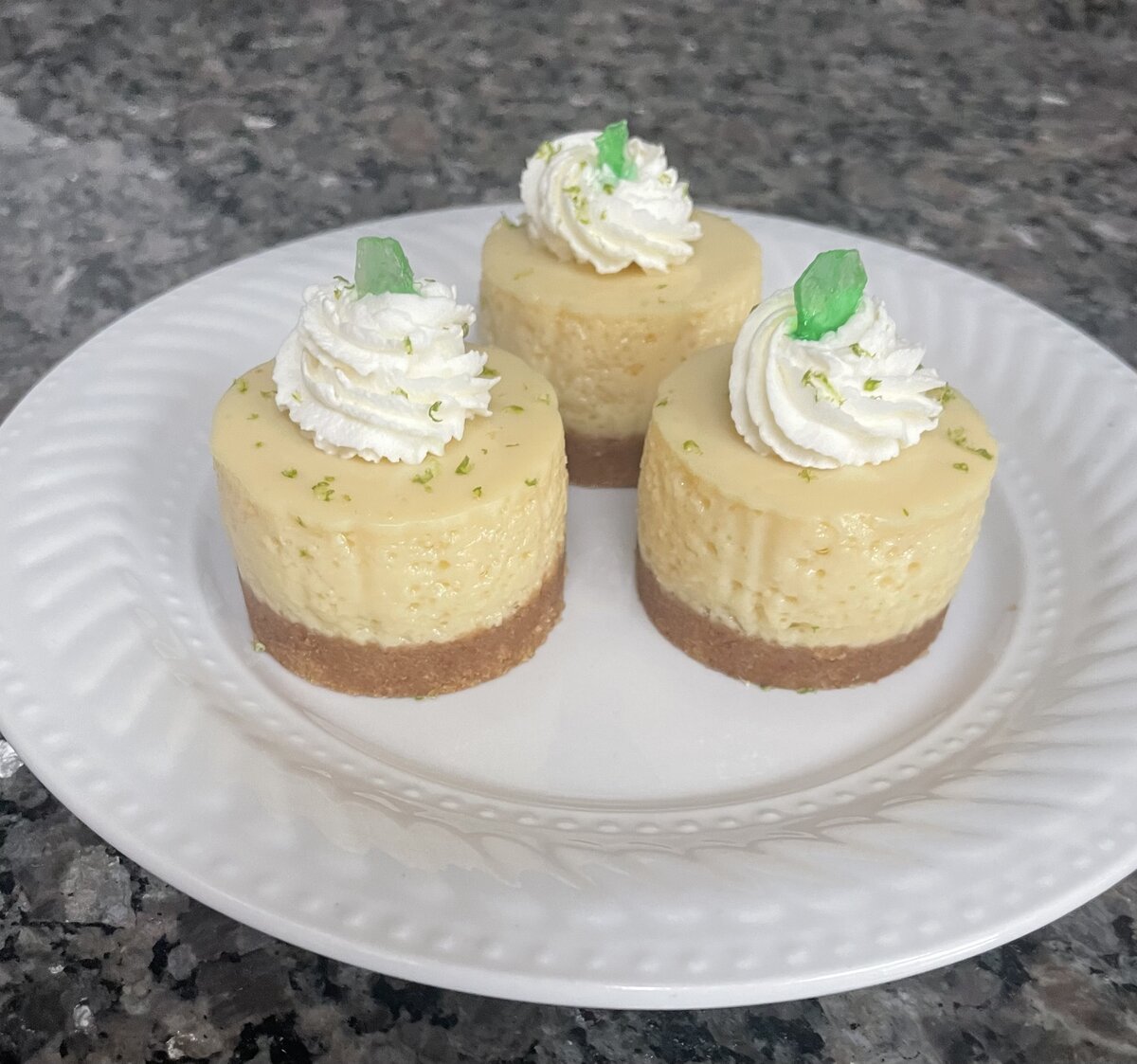 Individual sea glass themed cheesecakes with lime zest and green candy